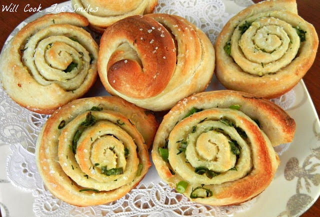 pastries on plate with doily on it on wood table as shown from above