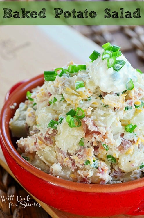 baked potato salad in a red bowl with sour cream chives on top