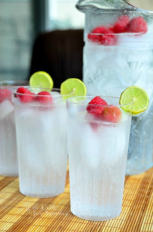 Raspberry Key Lime Italian Soda in a glass with lime and raspberries garnish