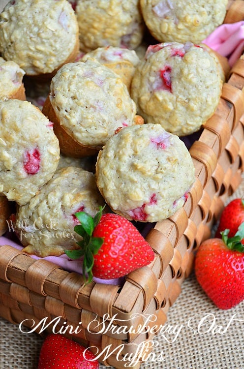 wicker basket filled with mini strawberry oat muffins with knife and butter spread on muffin on table