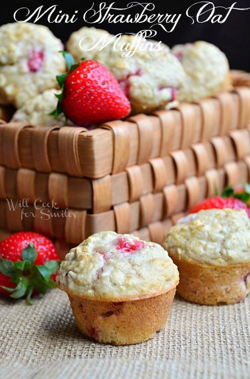 strawberry muffins on a table and the rest in a basket behind them