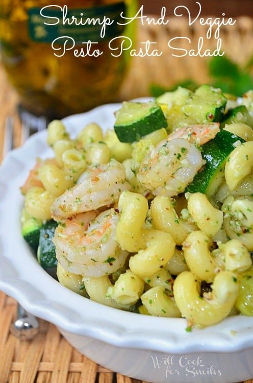 spiral pasta with shrimp and zucchini with herbs in a white bowl