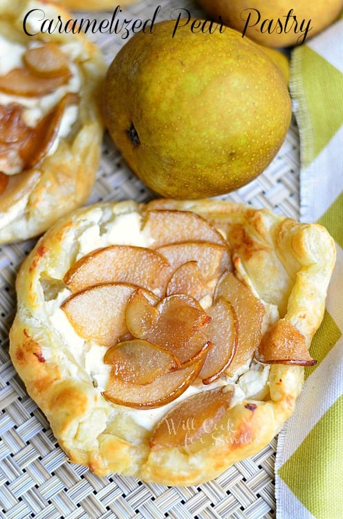 3 caramel pear pastries on table cloth with white and yellow cloth to right and 2 pears in background