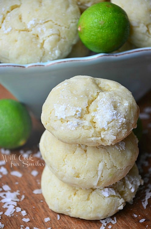 key lime cookies stacked on a wood cutting board