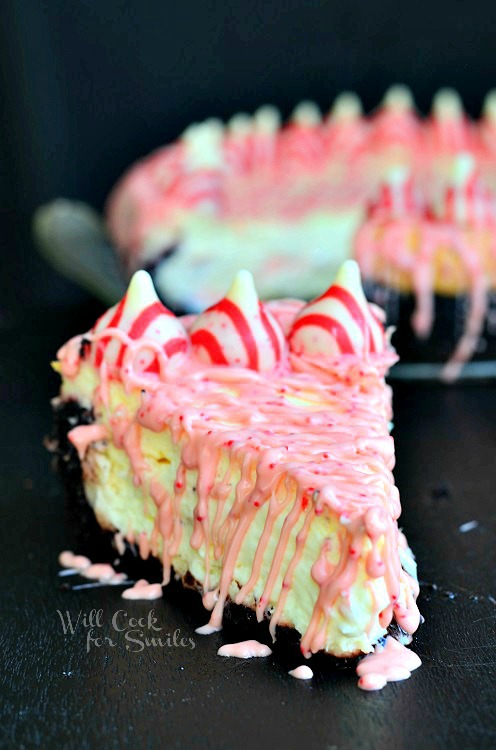 Peppermint Cheesecake with peppermint kisses along the outside and with Oreo Cake Crust slice