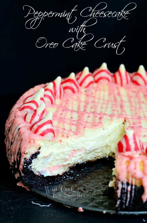 Peppermint Cheesecake with peppermint kisses along the outside and with Oreo Cake Crust with a slice out of it