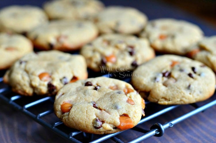 batch of peanut butter chocolate caramel cookies on cooling rack above wood table