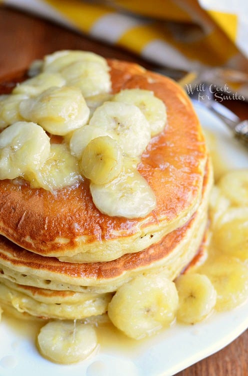 Bananas Foster Pancakes with sliced bananas on top on a white plate