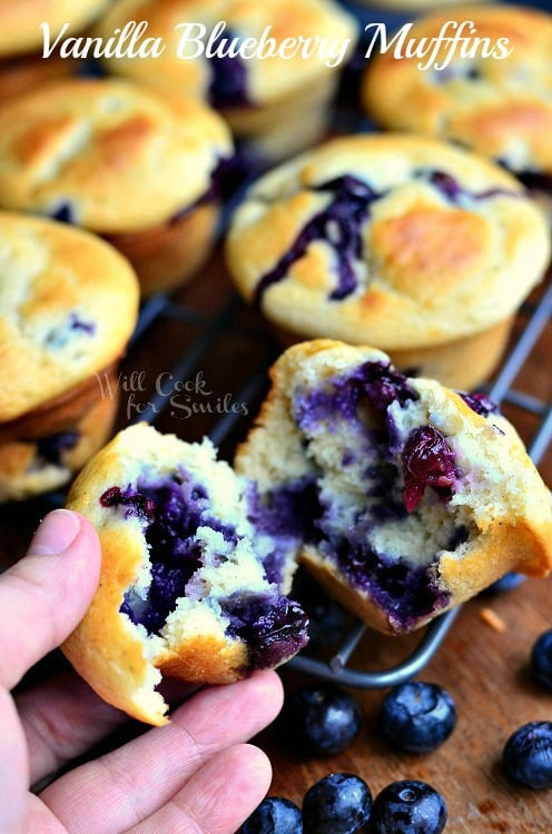 Vanilla Blueberry Muffins with one torn in half and I am holding a piece