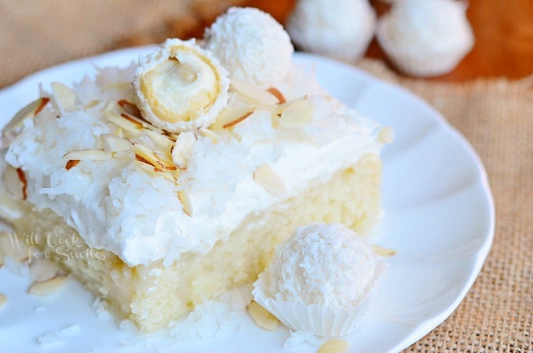 Raffaello Poke Cake Coconut Cake with White Chocolate Coconut Cream and Whipped Topping on a plate
