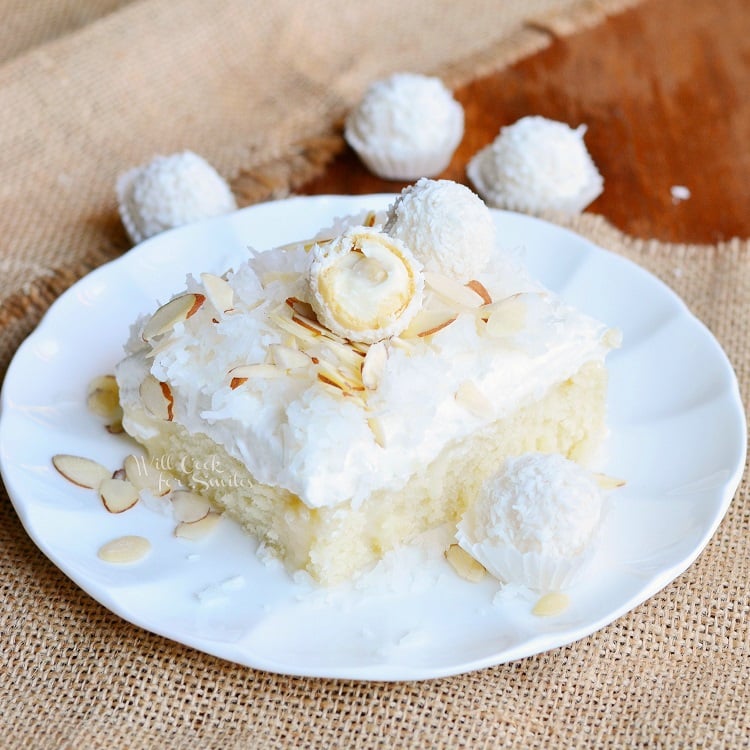 Raffaello Poke Cake Coconut Cake with White ChocolateCoconut Cream and Whipped Topping on a plate