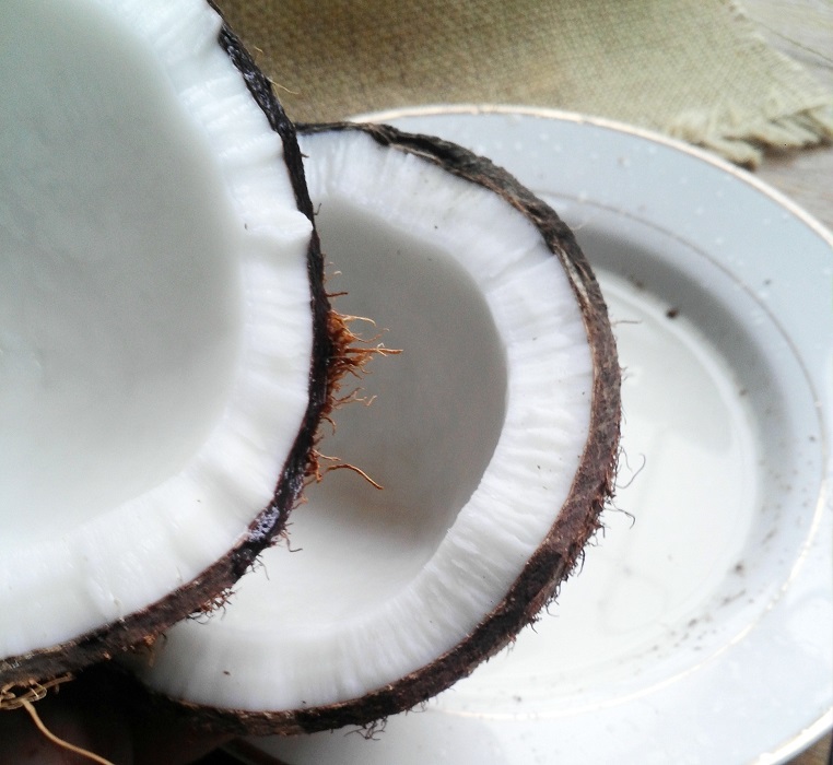 coconut cracked in half on a white plate