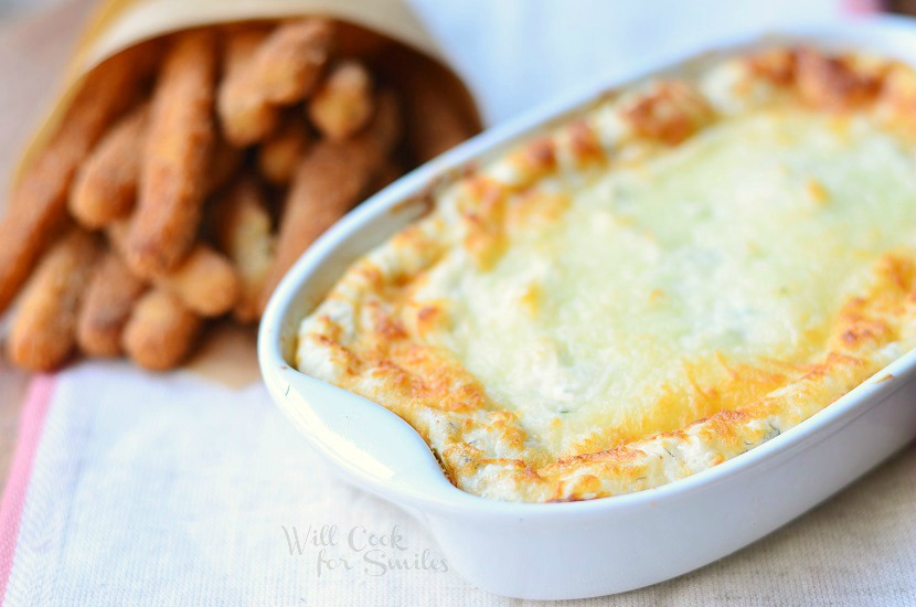 Cheesy Ranch Dip in a white casserole dish with chicken fries to the left