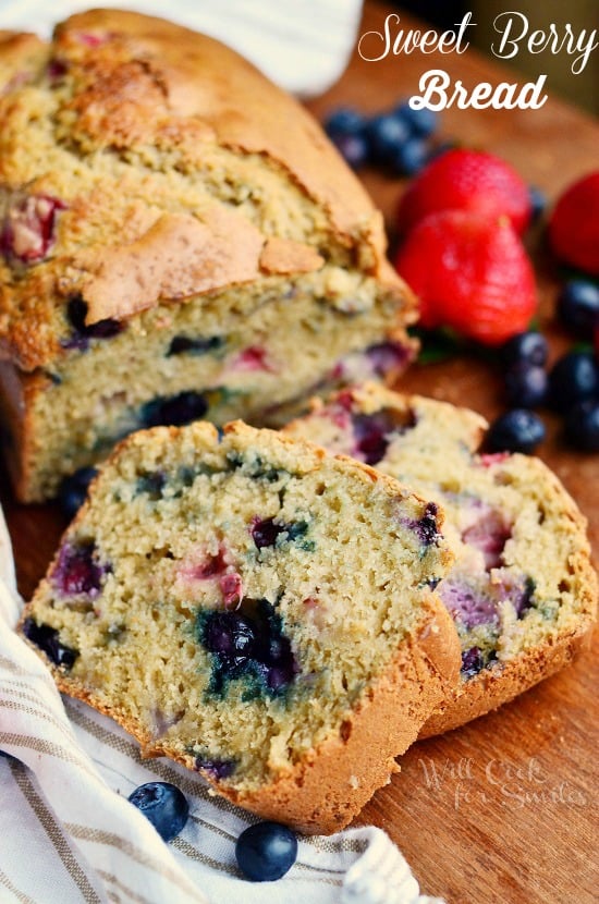 berry bread slices on a wood table with strawberry and blueberries in the background