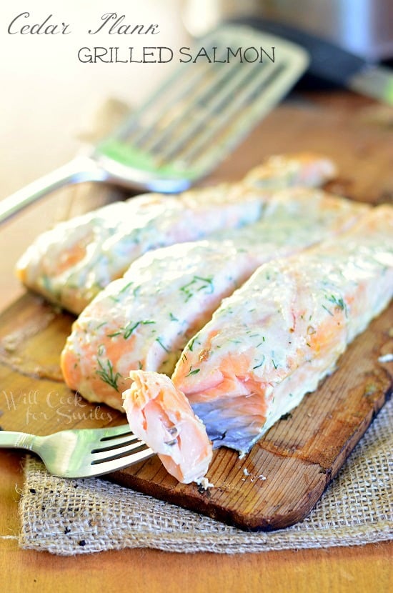 Cedar Plank Salmon smothered in creamy lemon dill sauce on a table