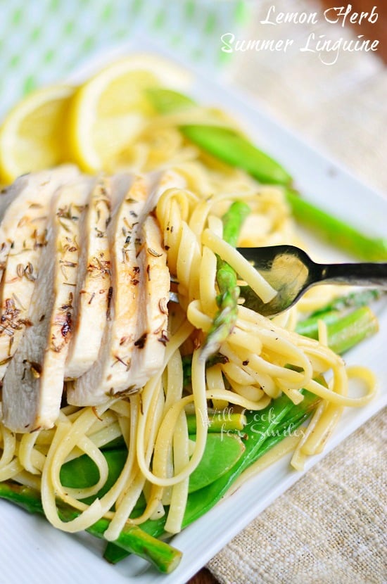 Linguine with Chicken, Asparagus and Snow Peas on a white square plate and with slices of lemon and a fork