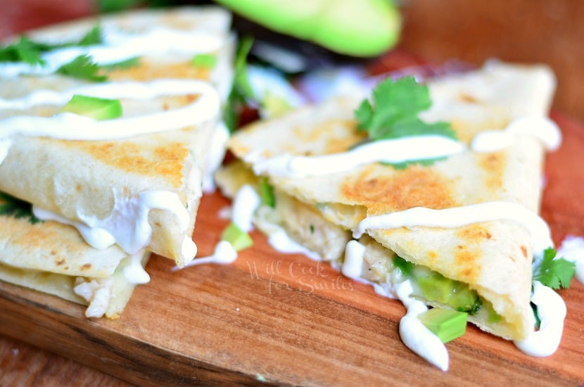 Avocado Chicken Quesadilla sliced up on a wood cutting board