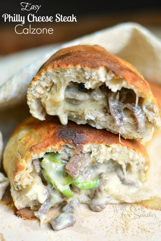 stacked halves of a easy philly cheese steak calzone on a tan cloth