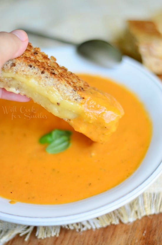 Tomato Bisque in a white bowl with a Smoked Gouda Grilled Cheese Dippers