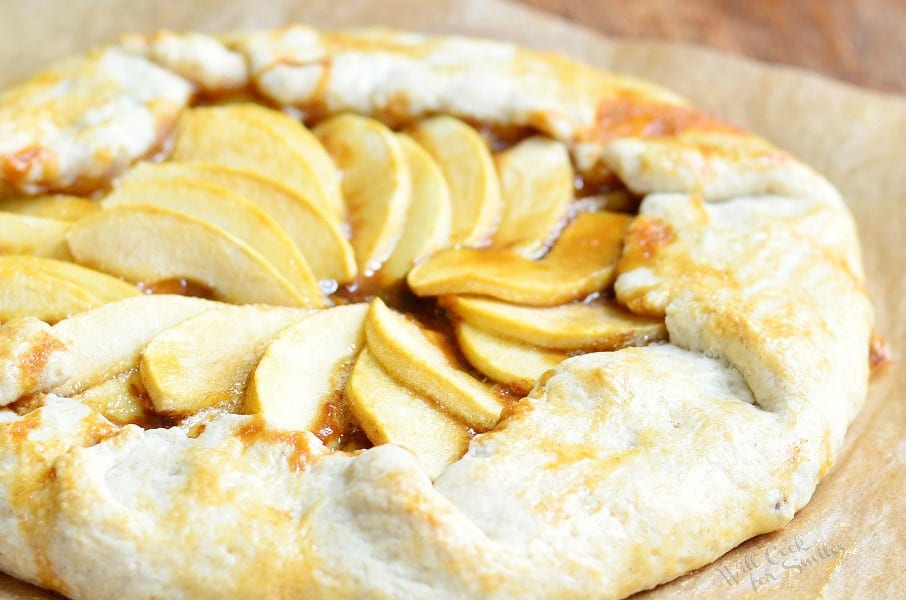 close up view of caramel apple galette on wax paper on wooden table