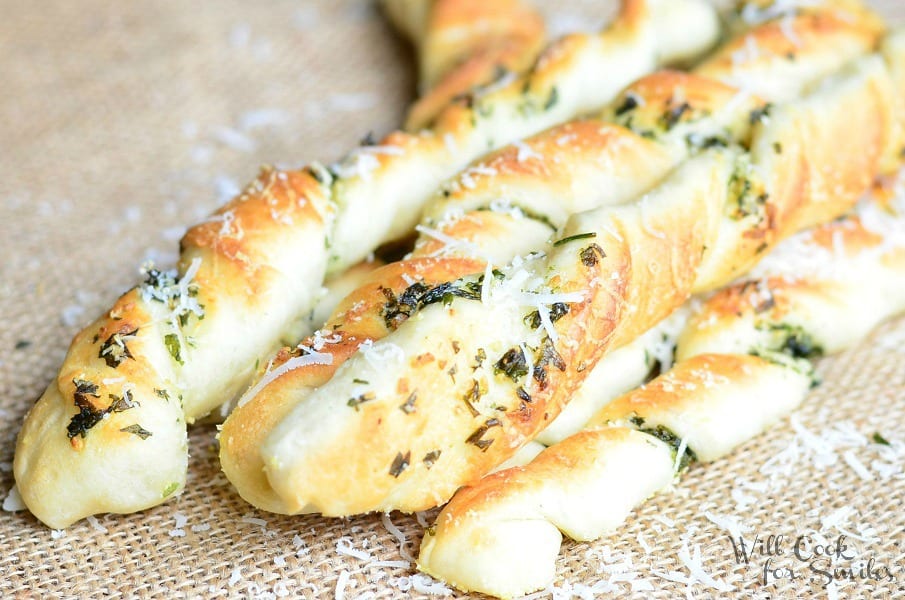 close up view of homemade paresan garlic herb breadsticks on a tan placemat