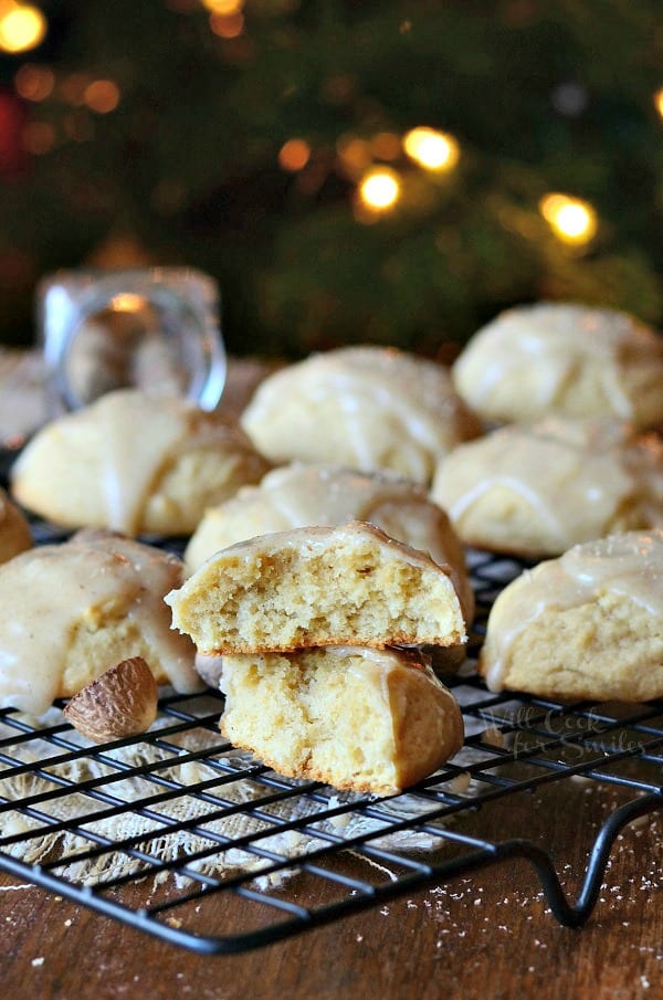 Eggnog Cookies with Eggnog Glaze on a cooling rack with one cookie cut in half and stacked on top of each other