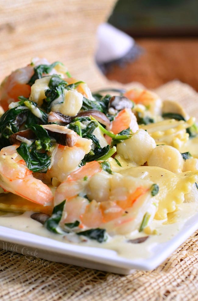 Ravioli with Seafood, Spinach & Mushrooms on a white plate