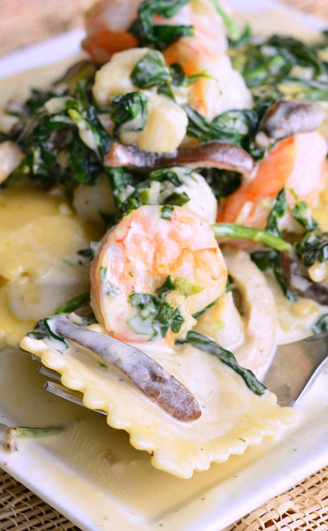 Ravioli with Seafood, Spinach & Mushrooms on a white plate
