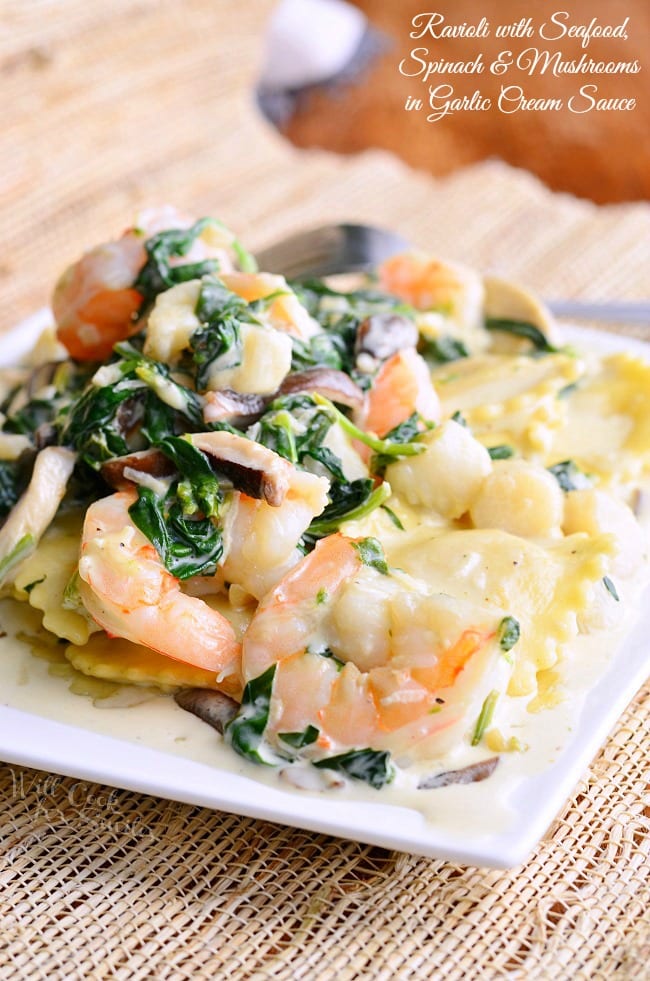 Ravioli with Seafood, Spinach & Mushrooms on a white plate