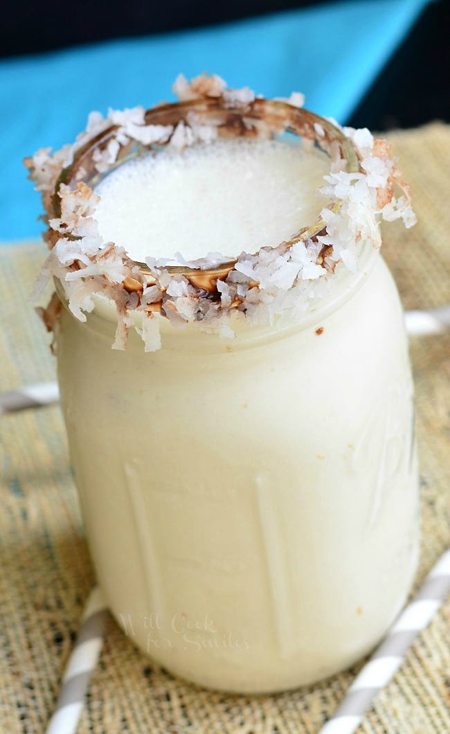 Milkshake in a mason jar with coconut flakes around the rim