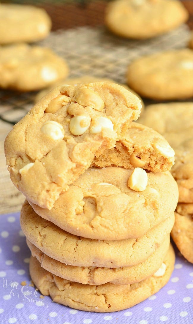 Peanut Butter White Chocolate Cookies stacked up on a napkin with the top cookie cut in half