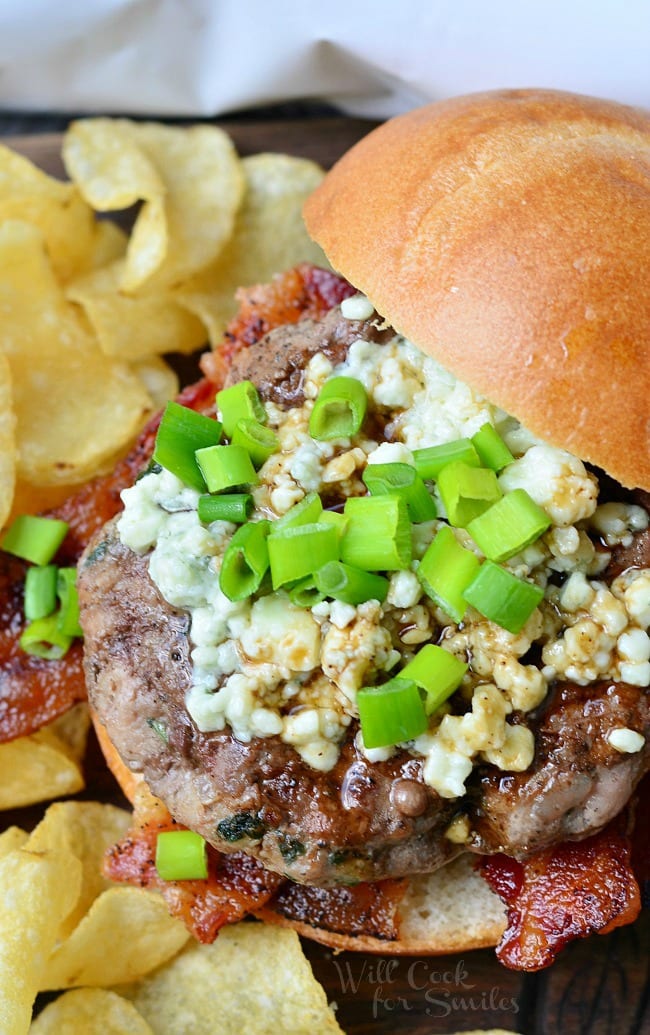 view from above of blue cheese bacon burger and chips on a wooden cutting board