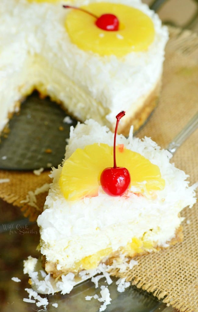 Top view of pina Colada Cheesecake with coconut, cherry, and pineapple