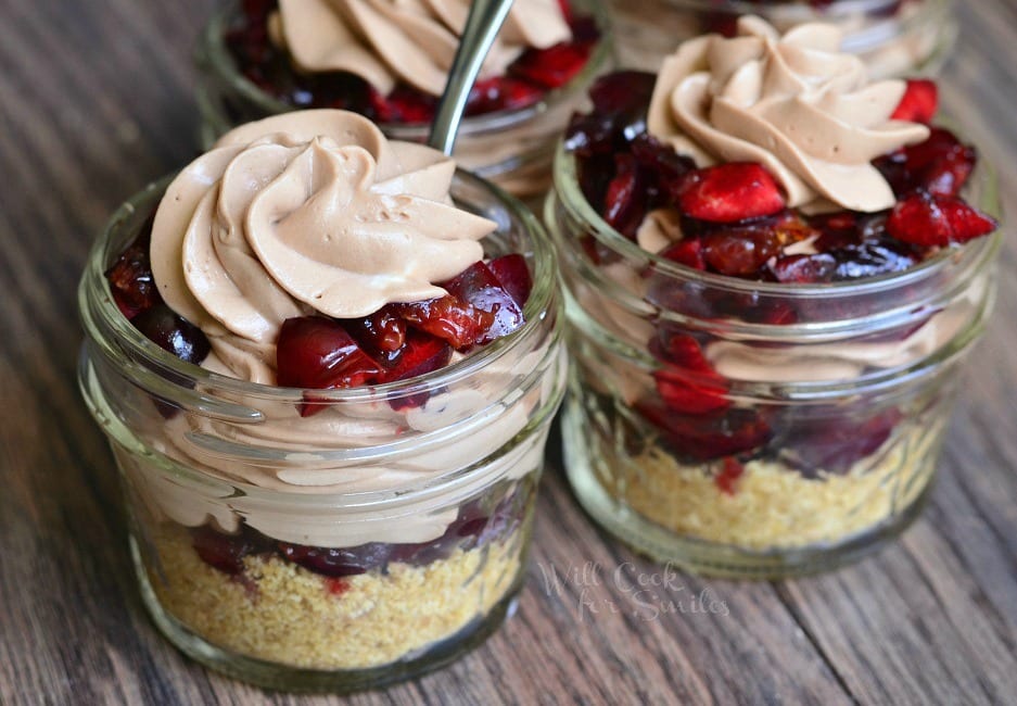 2 Chocolate Cherry Cheesecake Pie In A Jar with a spoon in one of them