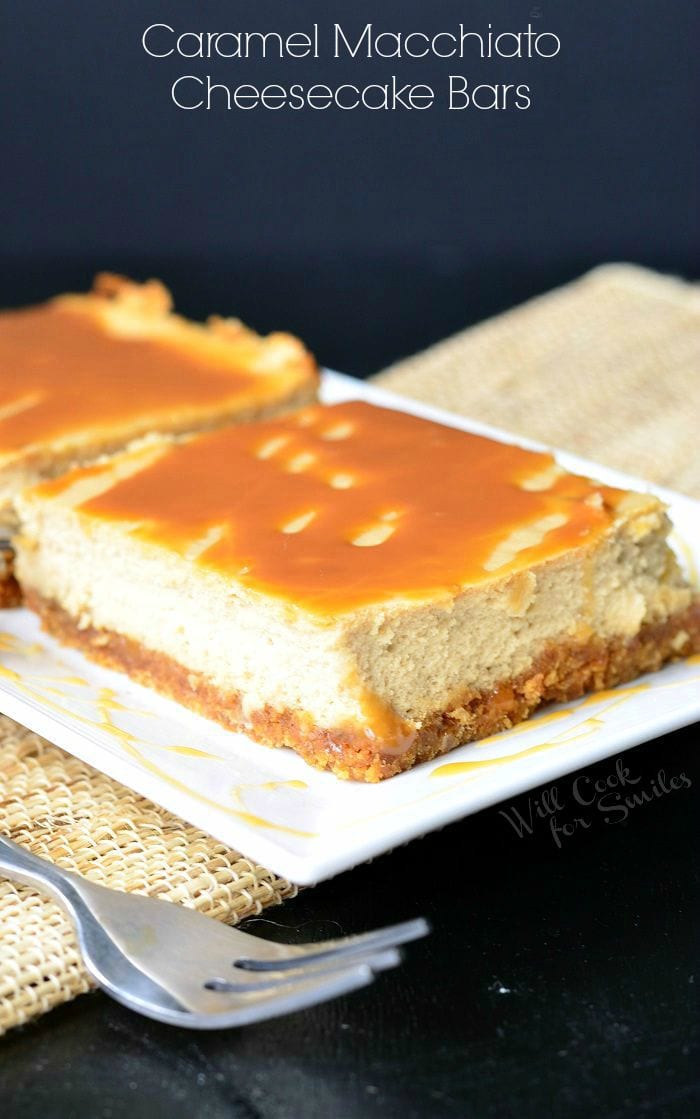 2 portions of caramel macchiato cheesecake bars on a white rectangular plate with a fork n the foreground