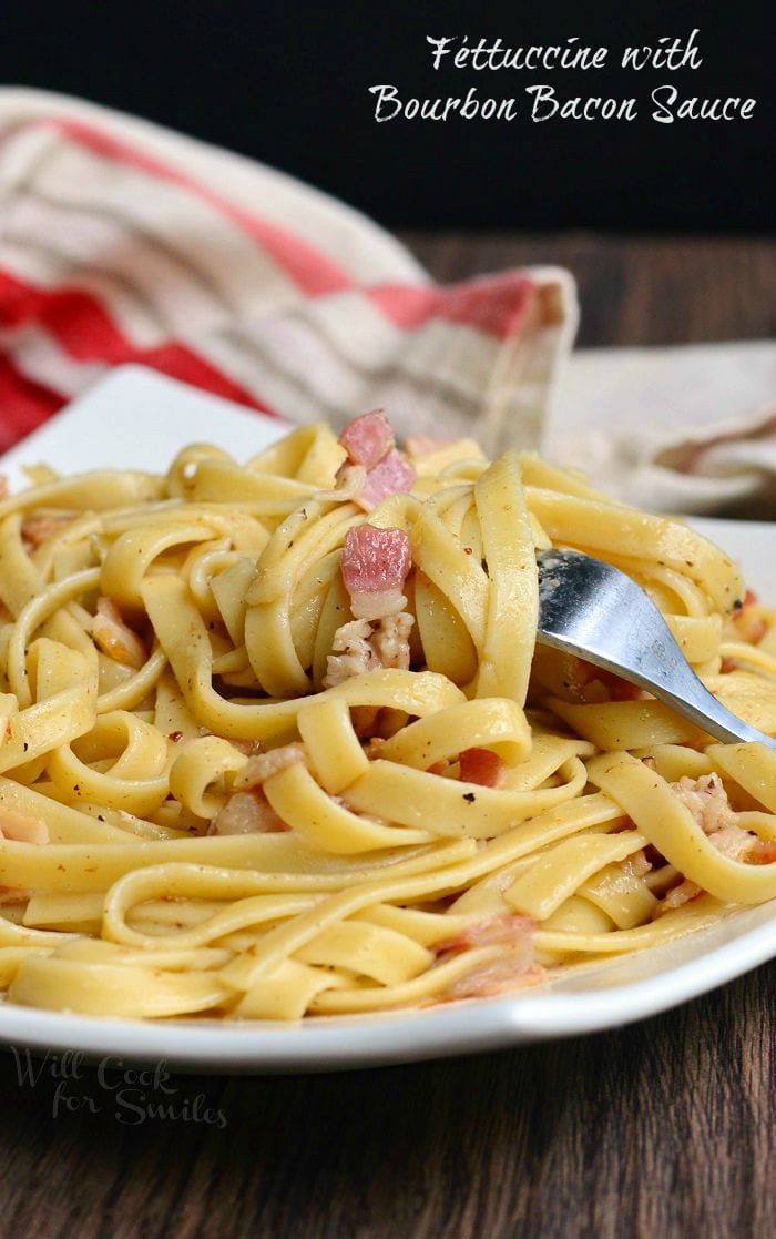 Fettuccine with Bourbon Bacon Sauce on a white plate with a fork