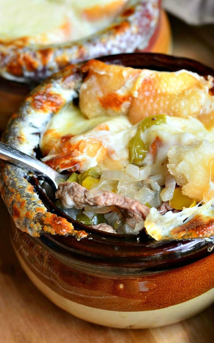 Philly Cheese Steak Soup in a bowl with cheese on top and spoon instide