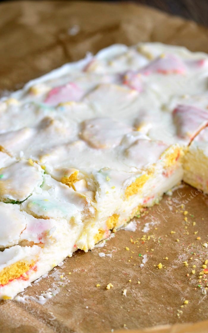 Sugar Cookie Fudge on parchment paper with some pieces cut out