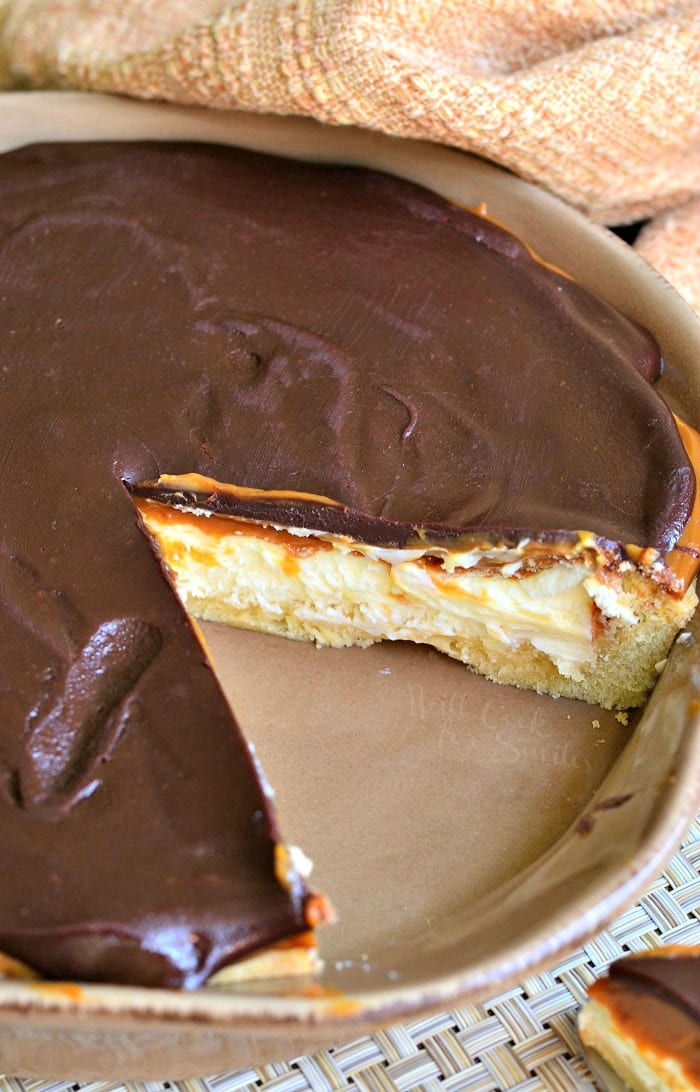 Twix Cheesecake Pie in a pie pan with slice of the pie cut out