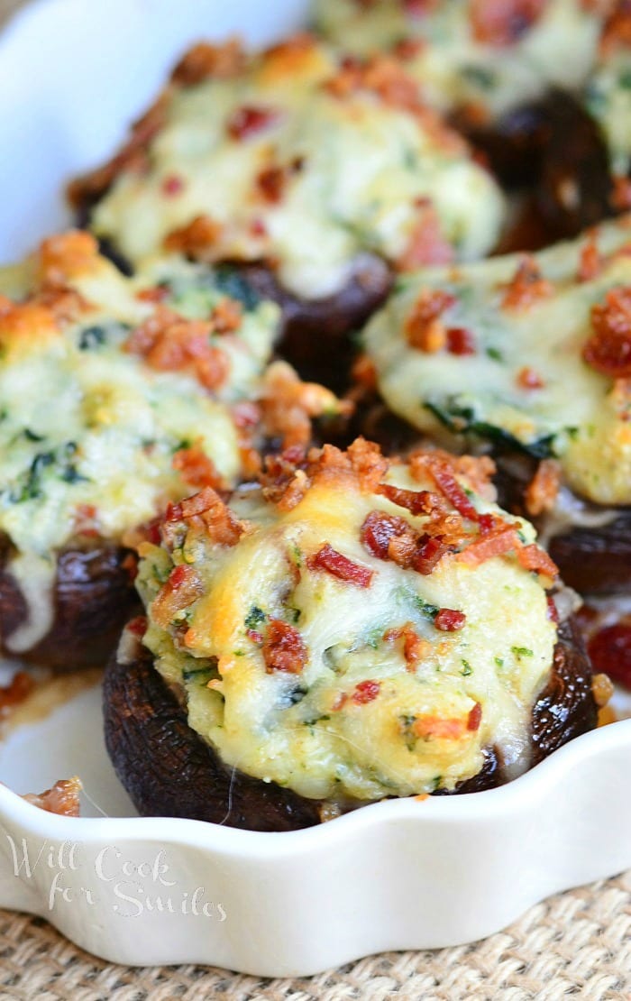 Decorative oval platter filled with bacon spinach and four cheese stuffed mushrooms