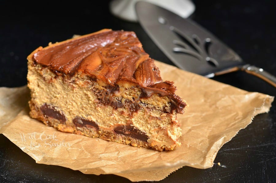 slice of Gingerbread Nutella Swirl Cheesecake on a piece of butcher paper with pie spatula at top right side