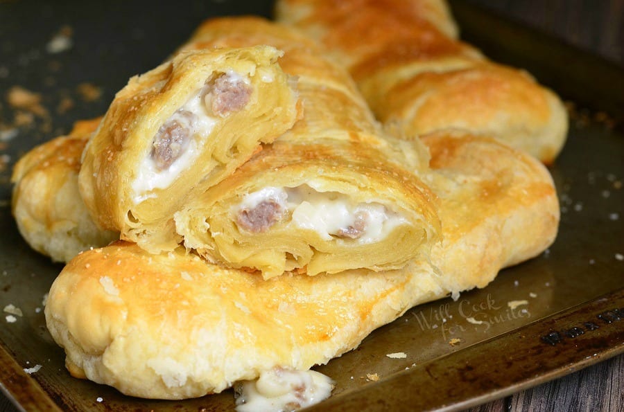 Pastry with sausage gravy and sausage in it on a baking sheet