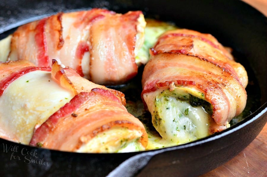 bacon wrapped chicken breast with cheese in a cast iron pan
