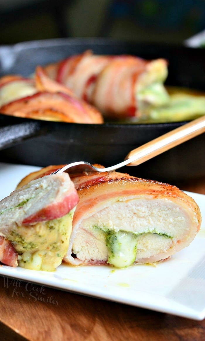 bacon wrapped chicken breast with cheese in a cast iron pan