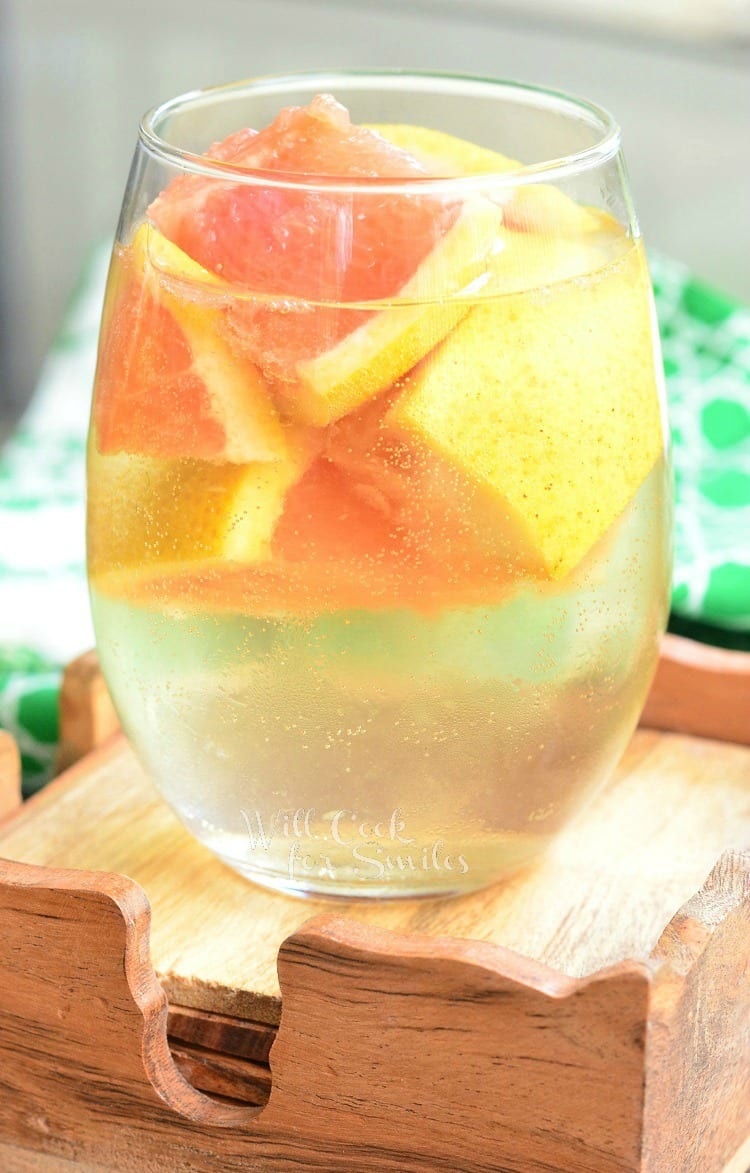 a wine glass with sangria and cut up grapefruit.