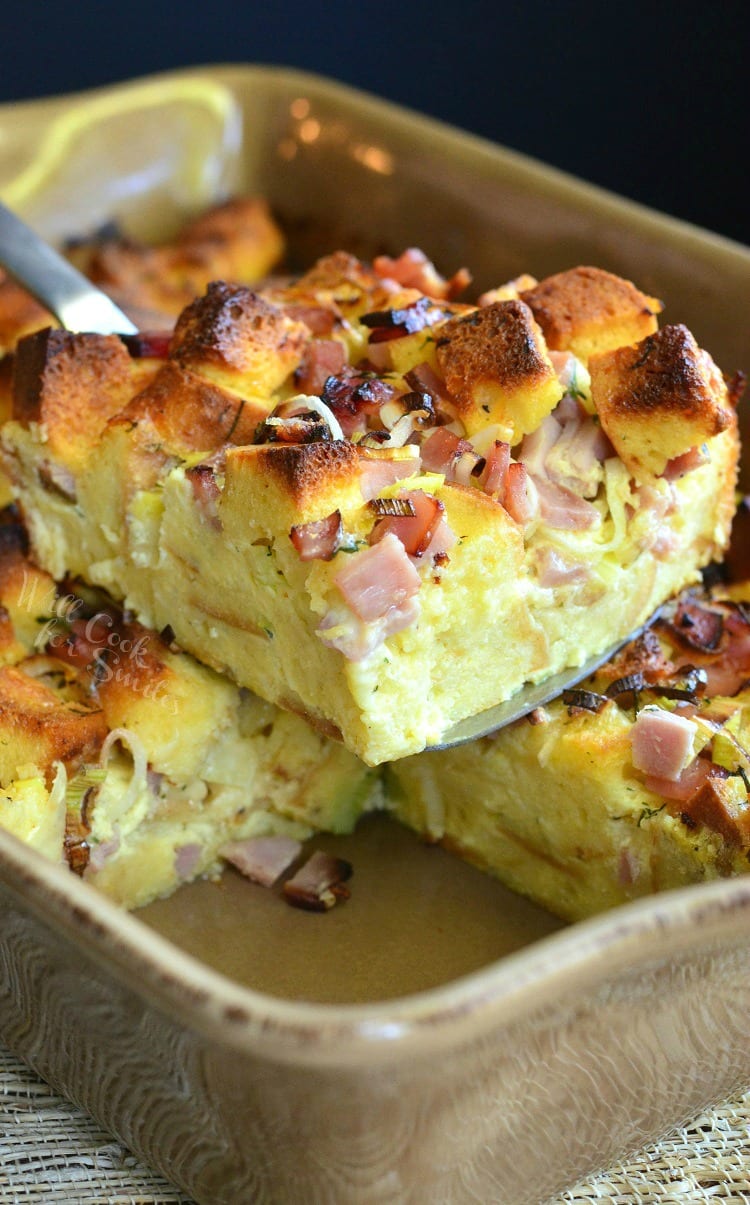 Ham Leek and Cheese Bread Pudding being lifted out of a baking pan with a spatula