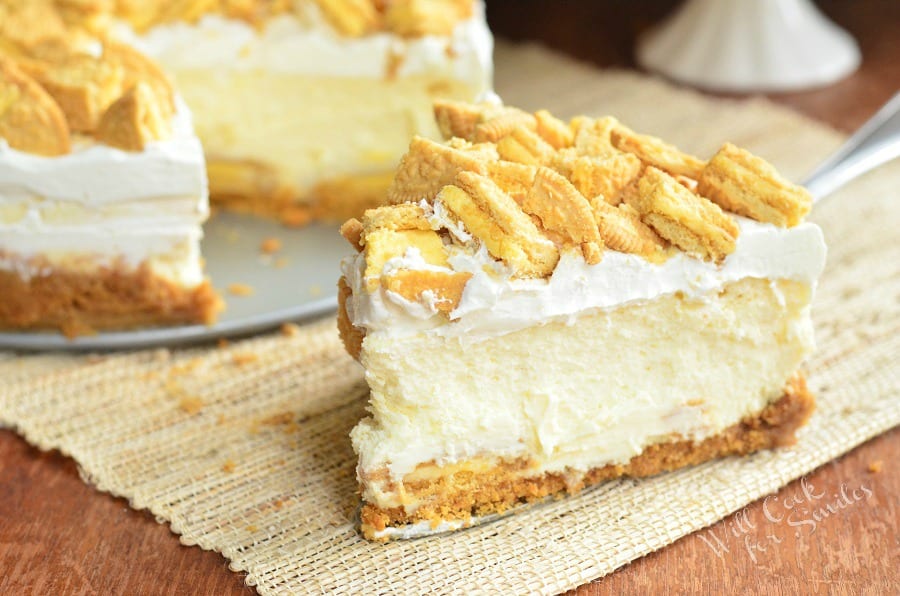 Lemon Oreo Cheesecake with crushed oreos on top and a slice of cheesecake on the table
