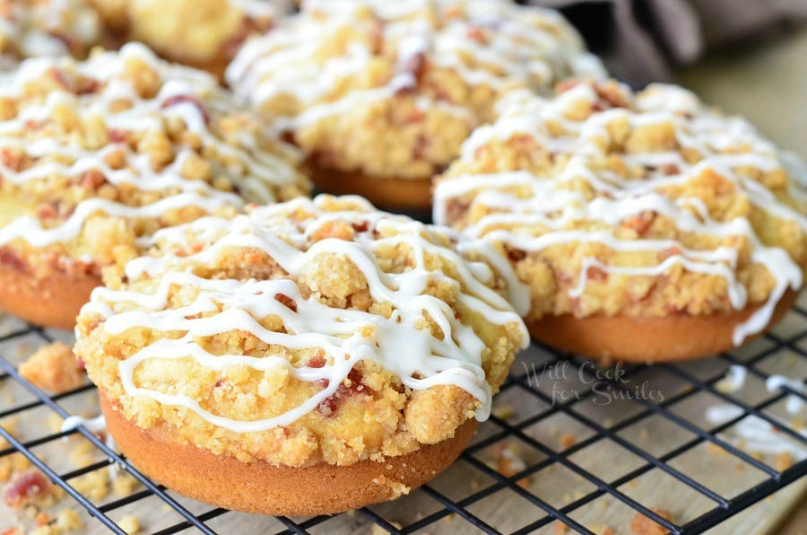 Bacon Crumb Doughnuts with icing and bacon on top on a cooling rack