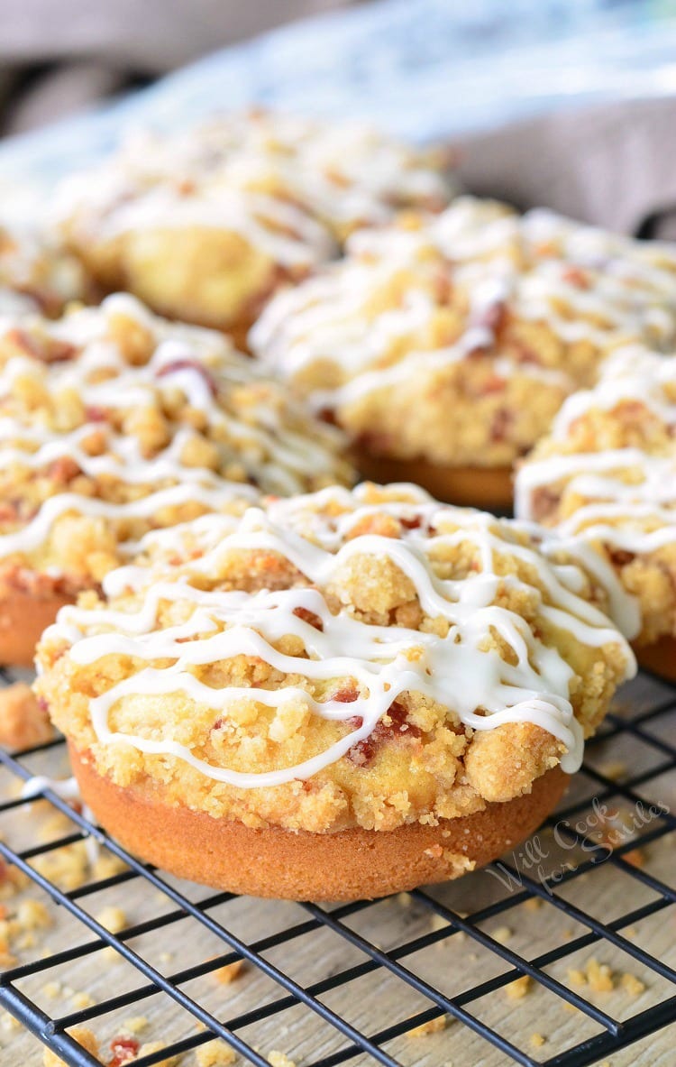 Bacon Crumb Doughnuts with icing and bacon on top on a cooling rack
