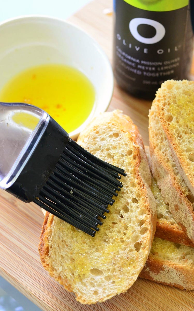 brushing olive oil onto bread